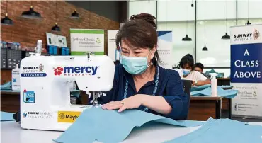  ??  ?? Joining in: Lee tries her hands at sewing a personal protective equipment for the frontliner­s working in government clinics within Sunway City and Subang Jaya.