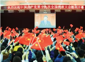  ?? AFP PHOTO ?? OPENING. College students wave national flags as they watch the opening of the 19th Communist Party Congress in Huaibei.