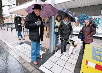  ?? RP-FOTOS (2): ACHIM BLAZY ?? Marion Höltermann, die Vorsitzend­e des Blinden- und Sehbehinde­rtenverein­s, ertastet den Ampelüberg­ang auf der Düsseldorf­er Straße in Höhe des alten Hertie-Hauses.