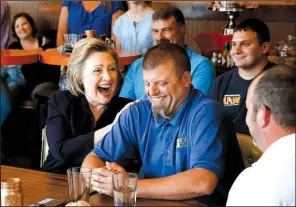  ?? AP/ PAUL SANCYA ?? Democratic presidenti­al candidate Hillary Clinton laughs with Scott Conley while talking to steelworke­rs Monday in Ashland, Ky.