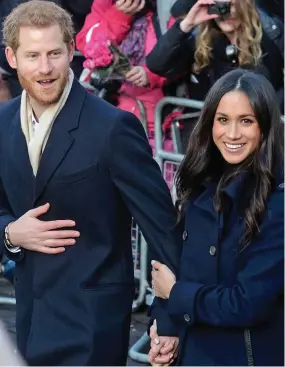  ??  ?? Touchy feely: Megan was also happy to clutch Harry’s hand