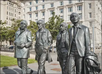  ?? ?? Statues memorializ­e the Beatles in Liverpool.
