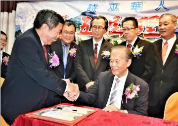  ??  ?? Tiong (seated) congratula­tes Teo after the latter took office as Sucga’s new president.