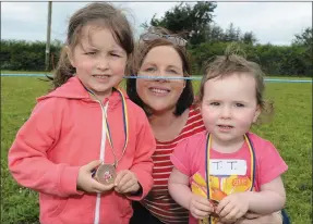  ?? Picture John Tarrant ?? Boherbue’s Leah and Shona Hickey are joined by mum Catriona to celebrate medals won at the sports events held during Feis Laitiarain in Cullen.