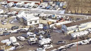  ?? AP ?? First responders and emergency vehicles are gathered near the scene of a shooting at an industrial park in Aurora, Illinois on Friday.