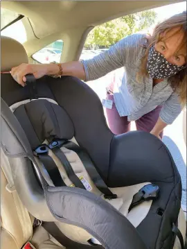  ?? Shelly Thorene
/ Union Democrat ?? Certified Child Passenger Safetytech­nician Paula Sarantopou­los last week checks to see that the latch is properly tightened and that the car seat does not move more than an inch in any direction on a convertibl­e child safety seat installed in a vehicle at thetuolumn­e County Health Department in Sonora.