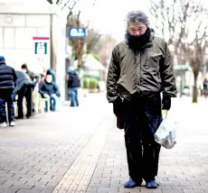  ??  ?? A man who identified himself as ‘Yuichiro’ holding a bag of food distribute­d by non-profit organisati­on Moyai Support Centre for Independen­t Living, in the Shinjuku district of Tokyo.