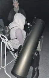  ?? PHOTO BY TORNEY VAN ACKER ?? NOVAC astronomer James Granahan provides a participan­t with a tantalizin­g view of the Andromeda galaxy through his 12-inch Dobsonian telescope.