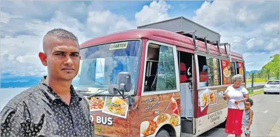  ?? Picture: ELIKI NUKUTABU ?? Food Bus owner Ravinesh Kumar stands beside his food truck while a customer buys arrives to buy food along the Queen Elizabeth Drive in Suva on Wednesday.
