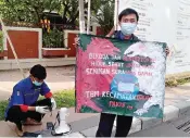  ?? SHABRINA PARAMACITR­A/JAWA POS ?? TURUN KE JALAN: Peserta aksi membawa poster sosialisas­i protokol kesehatan di Jalan Dukuh Kupang kemarin.