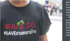  ??  ?? A farmer wears a T-shirt reading: ‘Banning NGO, #SaveThaiFa­rmers.’