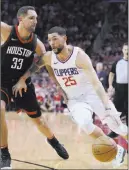  ?? George Bridges The Associated Press ?? Clippers guard Austin Rivers drives against Rockets forward Ryan Anderson in the first half of Los Angeles’ 128-118 win Friday at the Toyota Center.