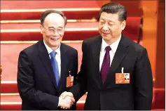  ??  ?? Wang (left) shakes hands with Xi during the fifth plenary session of the first session of the 13th National People’s Congress (NPC) at the Great Hall of the People in Beijing. — AFP photo