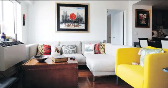  ?? PHOTOS: ALLEN McINNIS ?? Yellow armchairs bought at Ikea in Geneva help to brighten the comfortabl­e living room in Fizza Hameed and Ali Malik’s open plan apartment in Old Montreal.
