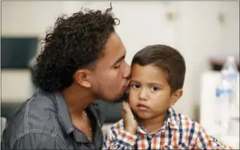  ?? RUBEN R. RAMIREZ — THE EL PASO TIMES VIA AP ?? Roger Ardino 24, gives his son Roger Ardino Jr., 3, a kiss on the cheek shortly after speaking to reporters at a news conference at the Annunciati­on House in El Paso, Texas, Wednesday. Ardino and Pablo Ortiz, 28, and his son Andres 3, spoke to the media about their experience­s while being detained and separated for several months from their sons. Tuesday night three fathers were reunited with their children but only two spoke this morning after the third, a father and daughter had already left El Paso early Wednesday morning.