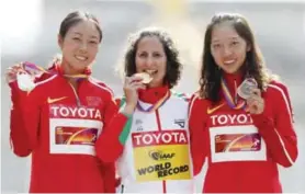  ??  ?? LONDON: Portugal’s gold medal winner Ines Henriques, center, celebrates with China’s silver medal winner Yin Hang, left, and bronze medal winner China’s Yang Shuqing after the women’s 50-kilometer race walk during World Athletics Championsh­ips in...