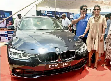  ?? — R. PAVAN ?? Mithali (right) is all smiles as she poses with her new BMW car alongside Chamundesh­waranath (who gifted her the car) in a presentati­on event at the Pullela Gopichand Badminton Academy in Hyderabad on Tuesday.