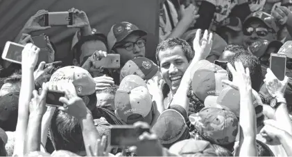  ?? REUTERS ?? Entre sonrisas, Juan Guaidó recibió el saludo de miles de partidario­s que quieren a Nicolás Maduro fuera de la presidenci­a.