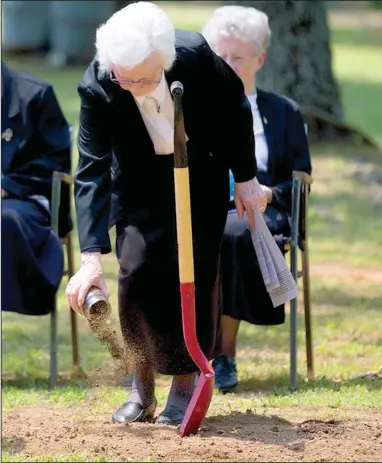  ?? Special to the Democrat-Gazette/KAREN SCHWARTZ ?? Prioress Maria DeAngeli pours soil from the grounds of St. Scholastic­a’s current monastery during a ritual symbolizin­g the blending of elements from the sisters’ past atop their anticipate­d future. Constructi­on of the sisters’ new home will begin in...