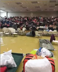  ??  ?? AP PHOTO VIA BEULAH JOHNSON In this photo provided by Beulah Johnson, evacuees sit in the bleachers at the Bowers Civic Center in Port Arthur, Texas, Wednesday, after floodwater­s caused by Tropical Storm Harvey inundated the facility overnight....