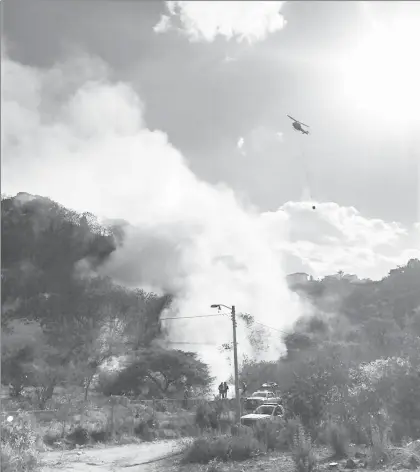  ??  ?? El incendio registrado en un cerro cerca del fraccionam­iento Bugambilia­s, en Zapopan, Jalisco, fue controlado por los bomberos la tarde de ayer. Se trata del quinto que se produce en la zona en lo que va del mes. Las acciones fueron apoyadas por un...