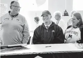  ?? [PHOTO BY CHRIS LANDSBERGE­R, THE OKLAHOMAN] ?? Oklahoma Christian School’s JP Morris, center, is all smiles with his parents John and Kelly as he prepares to sign a letter of intent to play lacrosse at Mount St. Mary’s University of Maryland on Wednesday.