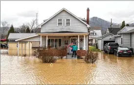  ?? RYAN C. HEMENS / LEXINGTON HERALD-LEADER ?? Catherine Castle stands on the porch of her home in downtown Paintsvill­e, Ky., as floodwater­s approach on Monday. Heavy thundersto­rms pounded parts of Appalachia, leading to multiple water rescues.