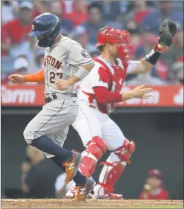  ?? JOHN MCCOY — THE ASSOCIATED PRESS ?? Houston’s Jose Altuve scores a run in the third inning against the Angels as catcher Max Stassi awaits a throw. The Astros won, 8-2, the Angels’ sixth loss in the past eight games.