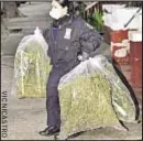  ??  ?? Cop carries out bags of marijuana found in basement of Bronx building after a fire spread odor across block.