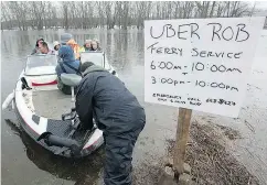  ?? ANDREW VAUGHAN / THE CANADIAN PRESS ?? Rob Dekany, known as Uber Rob, ferries stranded passengers at Darlings Island, N.B., on Thursday as the Kennebecas­is River flooded the only road into the community. Dekany has refused to accept any payment.