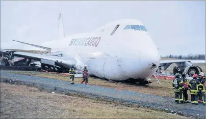  ?? CP PHOTO ?? A SkyLease Cargo plane skidded off a runway at Halifax Stanfield Internatio­nal Airport and stopped near a road early on Wednesday. The airport activated its emergency operations centre and suspended all flights after the incident.