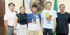  ?? ?? Asian Age-Group Swimming Championsh­ips gold medalist Jamesray Mishael Ajido (center) poses with Antipolo City Mayor Casimiro ‘Jun’ Ynares III (fourth from left) during his recent courtesy call at city hall. With them are (from left): KG Management director Jun Basas Esturco, Lovell Ajido, the swimmer’s mother, and coach Sherwin Santiago.