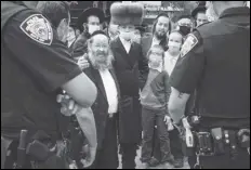  ?? ASSOCIATED PRESS ?? Members of the Orthodox Jewish community speak with NYPD officers Wednesday on a street corner in the Borough Park neighborho­od of Brooklyn. Gov. Andrew Cuomo moved to reinstate restrictio­ns on businesses, houses of worship and schools in and near areas where Coronaviru­s cases are spiking.