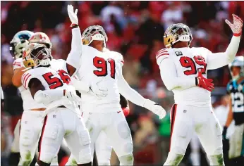  ?? Bay Area News Group/tns ?? Kwon Alexander (56), Arik Armstead (91) and Deforest Buckner (99) celebrate a tackle during a game against the Carolina Panthers at the Levi’s Stadium in Santa Clara on Oct. 27. BELOW: San Francisco 49ers’ Deforest Buckner, center, talks to members of the media as the team clears out their lockers at Levi’s Stadium in Santa Clara on Wednesday.