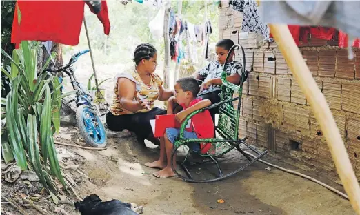  ??  ?? ZONA RURAL
Márcia se desdobra para ajudar os filhos Lázaro e Lucas nas tarefas enviadas pela escola pelo WhatsApp. “Tem vezes que o sinal cai, mas eles estão aprendendo”, diz