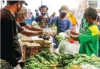  ?? BOY SLAMET/JAWA POS ?? GRATIS: Polri dan TNI menyediaka­n bahan makanan untuk memenuhi kebutuhan warga yang melakukan isolasi mandiri.