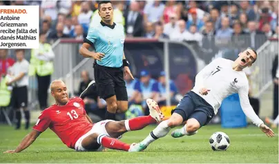  ??  ?? FRENADO. Antoine Griezmann recibe falta del danés Mathias Jorgensen.