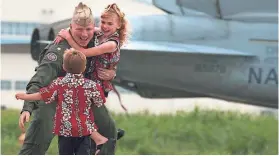  ?? PH1(SW) AARON ANSAROV / U.S. NAVY ?? Cmdr. Doug McGowen assigned, to the “Diamondbac­ks” of Strike Fighter Squadron One Zero Two (VFA-102), is greeted by his family after a three-month separation.