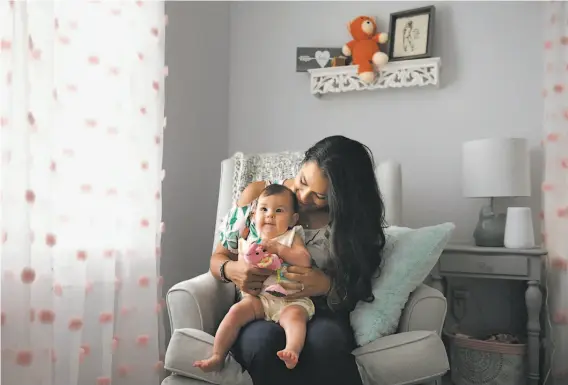  ?? Jessica Hill / New York Times ?? Nicole Roberts, with 5-month old daughter Amelia, is among a growing number of women who are seeking out fertility apps and wearable devices, such as Ava.