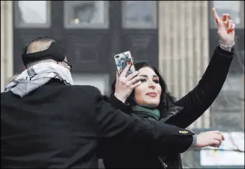  ?? Kathy Willens The Associated Press ?? Laura Loomer films herself as she is escorted off the stage after interrupti­ng Women’s March NYC director Agunda Okeyo at a rally Saturday in New York.