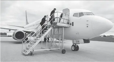  ?? JASON KRYK ?? Sunwing Vacation first officer James Parsons and captain Peter Budnik board a jet before departing from Windsor Internatio­nal Airport on Friday. Airport revenues climbed to $7.1 million in 2016 and its passenger volume took off.