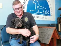  ?? Staff photo by Hunt Mercier ?? ■ Charles Lokey, director of Animal Care and Adoption Center in Texarkana, Ark., holds Velvet, a wired-hair terrier that has become the facility’s mascot. Velvet was a house surrender dog that was turned over by the owner and has become part of the family at Animal Care and Adoption Center.