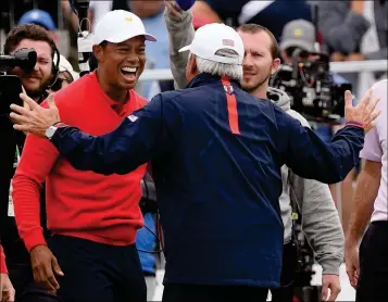  ?? ASSOCIATED PRESS ?? U.S. TEAM PLAYER AND CAPTAIN TIGER WOODS (LEFT) celebrates with vice captain Fred Couples after Woods won his singles match during the Presidents Cup golf tournament at Royal Melbourne Golf Club in Melbourne, Sunday.