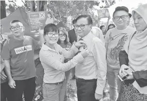  ?? — Gambar Bernama ?? SEMAT LENCANA: Wong (dua kiri) memakaikan lencana ‘Saya Bangsa Malaysia’ kepada Mohd Annuar ketika berkempen di Bandar Tun Hussein Onn di Kuala Lumpur semalam.