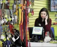  ?? ANNIE RICE — THE ASSOCIATED PRESS ?? Caitlin Swedroe talks to a customer over the phone at Two Bostons Pet Boutique, Wednesday in Naperville, Ill. Swedroe, 29, is a manager at the store.