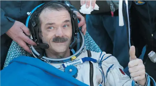  ?? MIKHAIL METZEL/AFP/GETTY IMAGES ?? Canadian spaceman Chris Hadfield gives a thumb up shortly after the landing aboard the Russian Soyuz space capsule in central Kazakhstan on May 14.