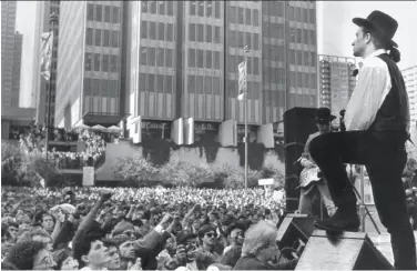  ?? United Press Internatio­nal 1987 ?? Bono surveys a crowd estimated at 20,000, in business suits and blue jeans, that turned out at Justin Herman Plaza on Nov. 11, 1987, for the free show that promoter Bill Graham arranged in less than 24 hours.