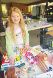  ?? (Special to NWA Democrat-Gazette/Sally Carroll) ?? Cecilia Dickey, 8, works at a garage sale April 30 in Bella Vista.