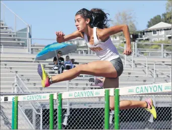  ?? Katharine Lotze/The Signal (See additional photos at signalscv.com) ?? (Above) Canyon’s Seanna Nalbandyan clears a hurdle ahead of the pack in the girls 100 meter hurdles during a dual track meet against Valencia at Canyon on Thursday.