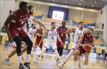  ??  ?? Qatar’s star guard Abdulrahma­n Saad (right) shapes up to make a basket during the the FIBA Asia Cup 2021 qualifier clash against Syria at the Al Gharafa Sports Club on Saturday. Saad scored 23 points with 7 rebounds and 3 assists.